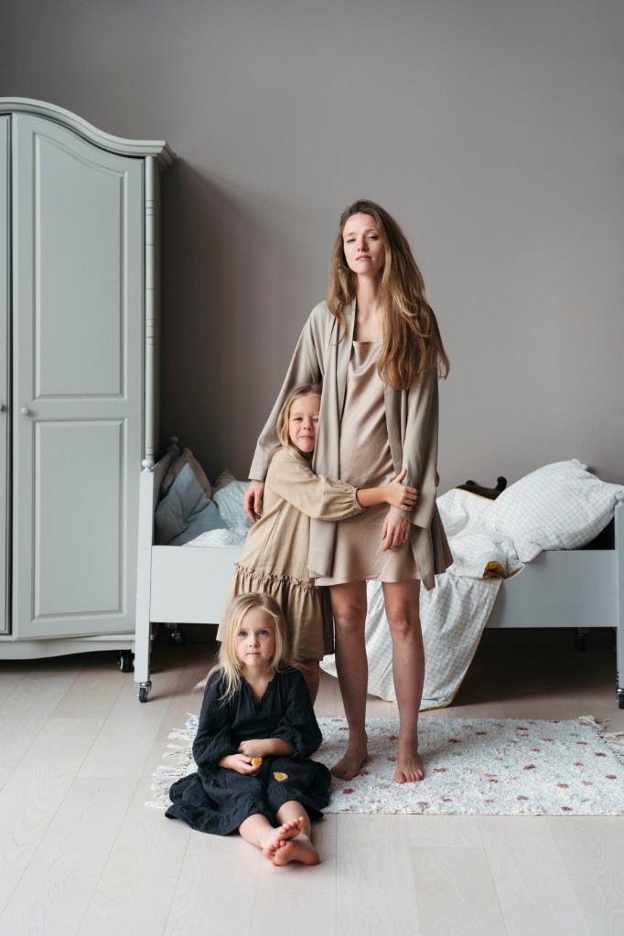 Mother standing with her children in a bedroom