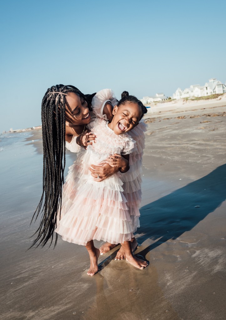 Mother laughing with her child in the shallows at the beach