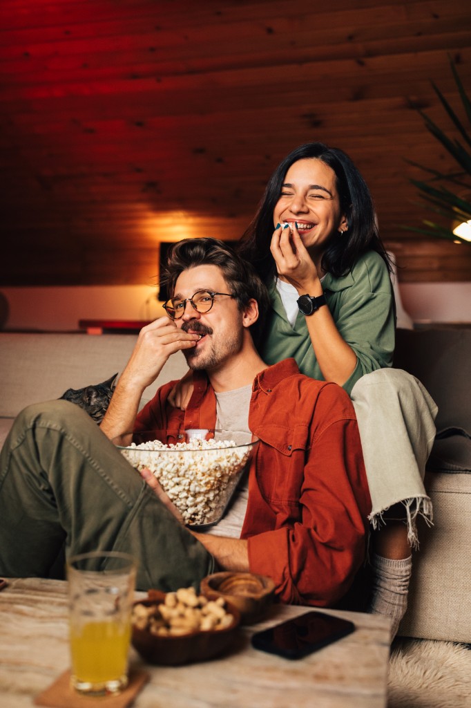 Couple sharing popcorn on the couch during movie night